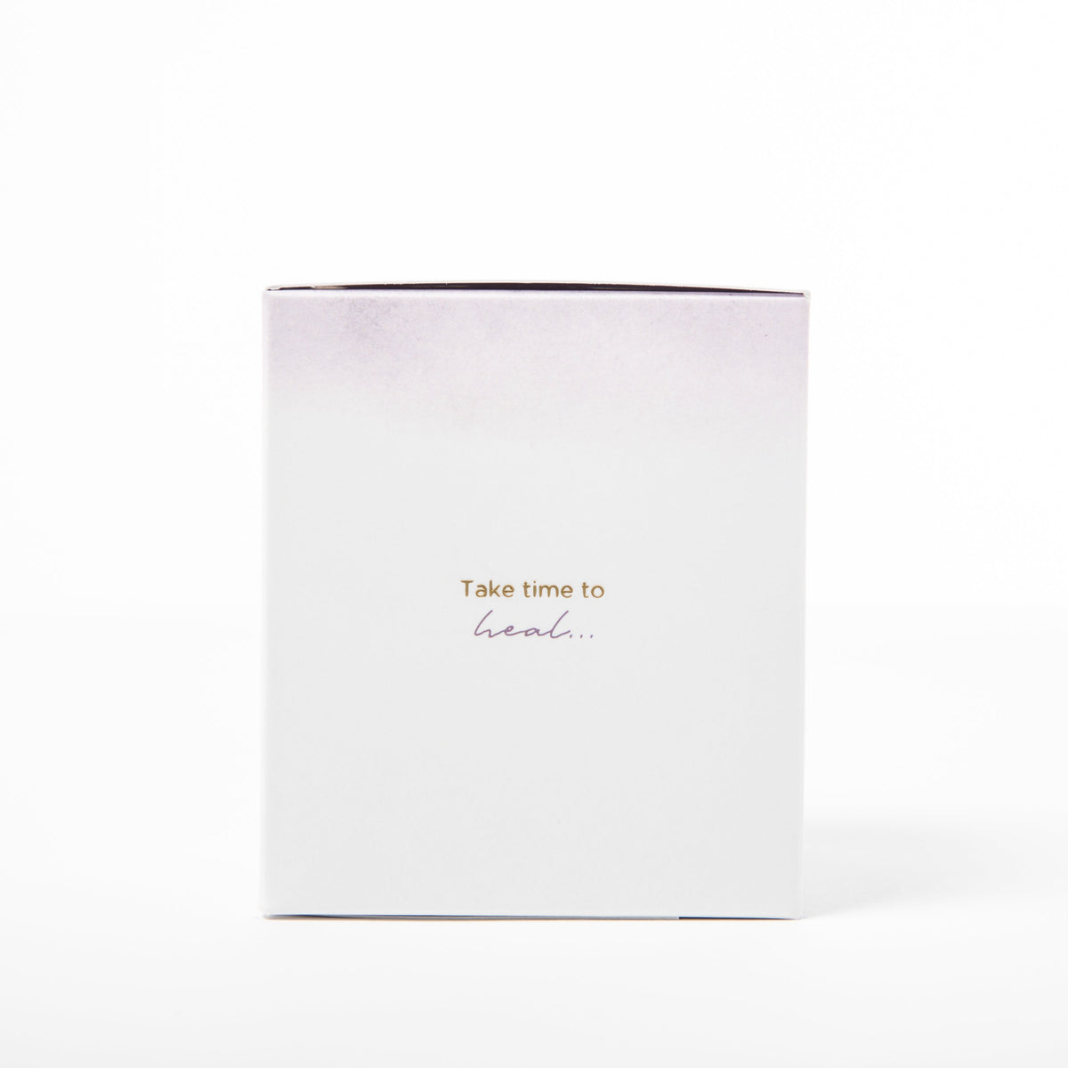 White candle with gold text 'Take time to heal' on a white background
