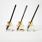 Three Shifa Aromas diffusers with black reeds on a white background