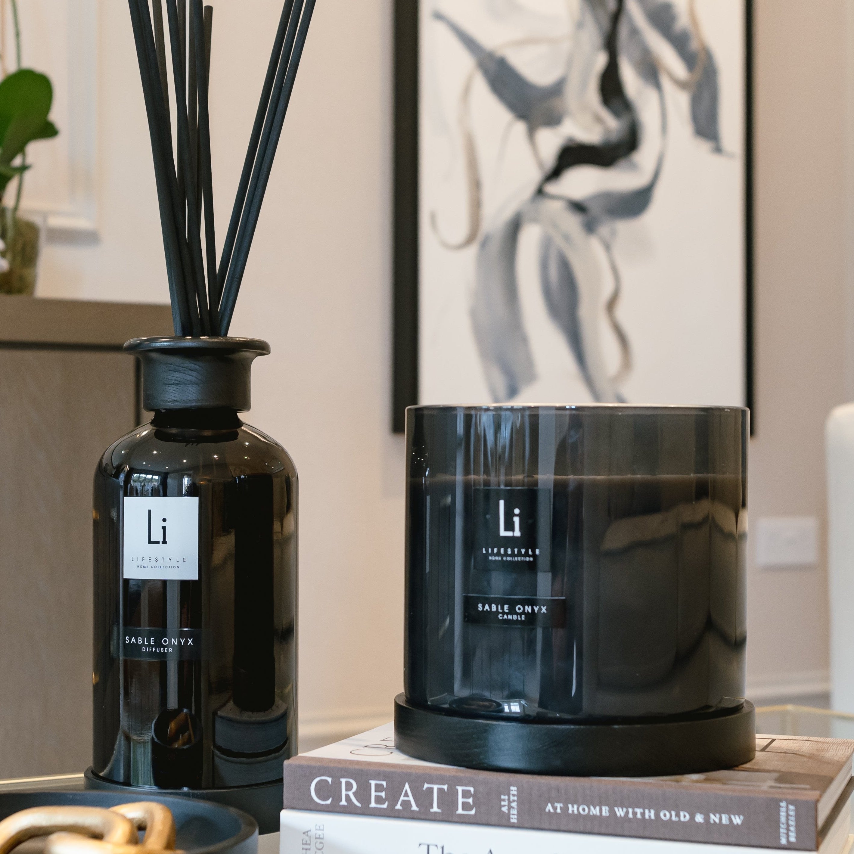 Black diffuser and candle on books with a modern interior background