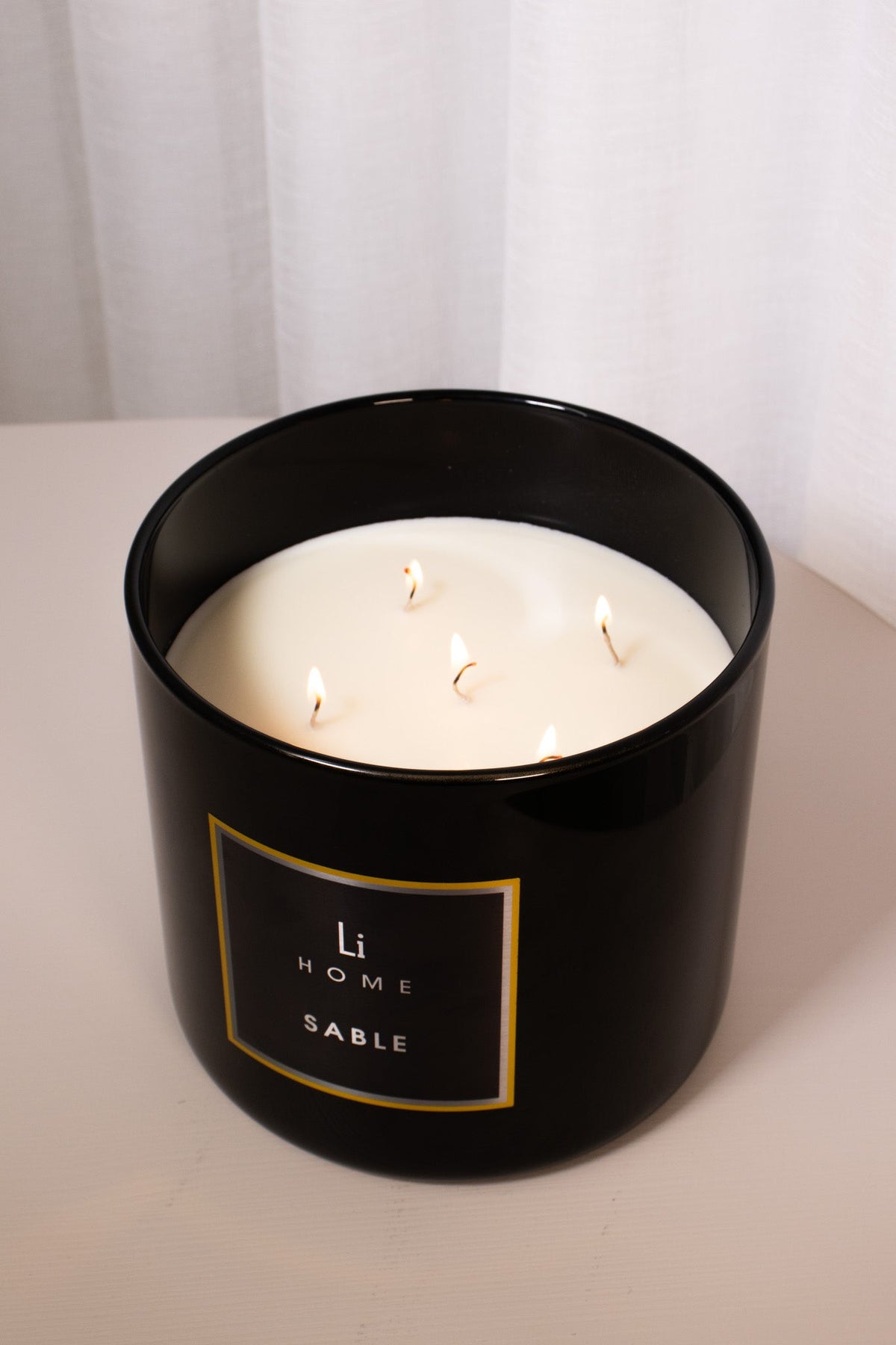 Black candle jar with 'Li Home Sable' label on a white background