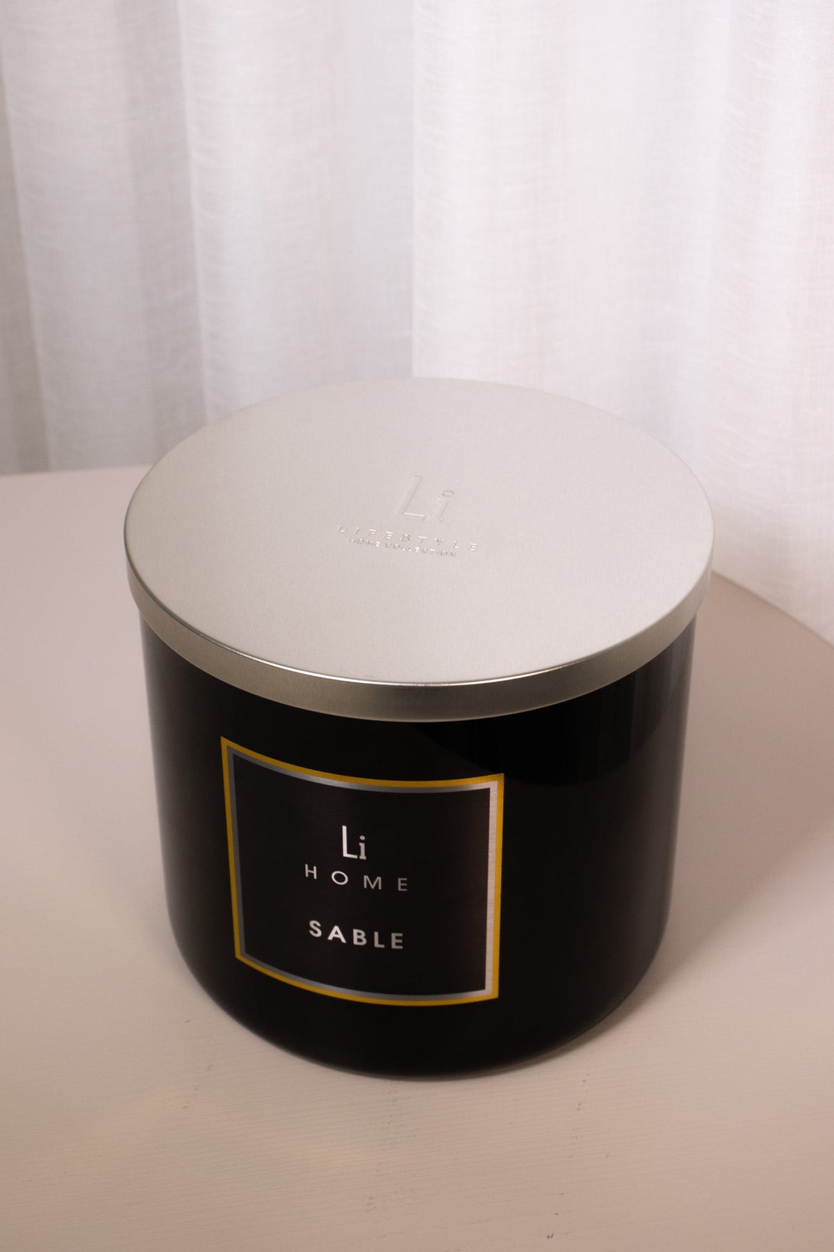 Black candle jar with 'LH Home' label on a white background