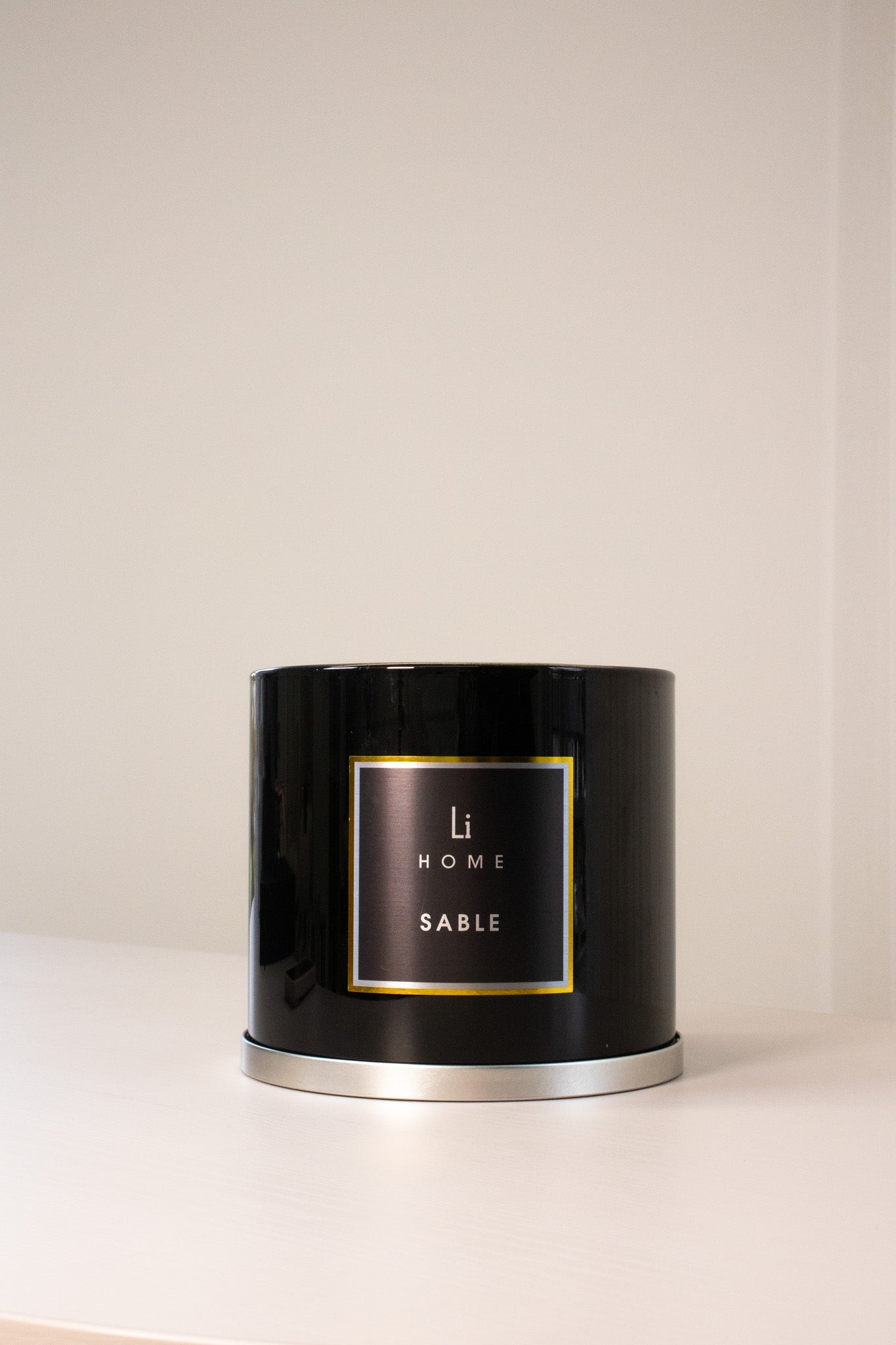 Black candle with 'Li Home Sable' label on a beige background