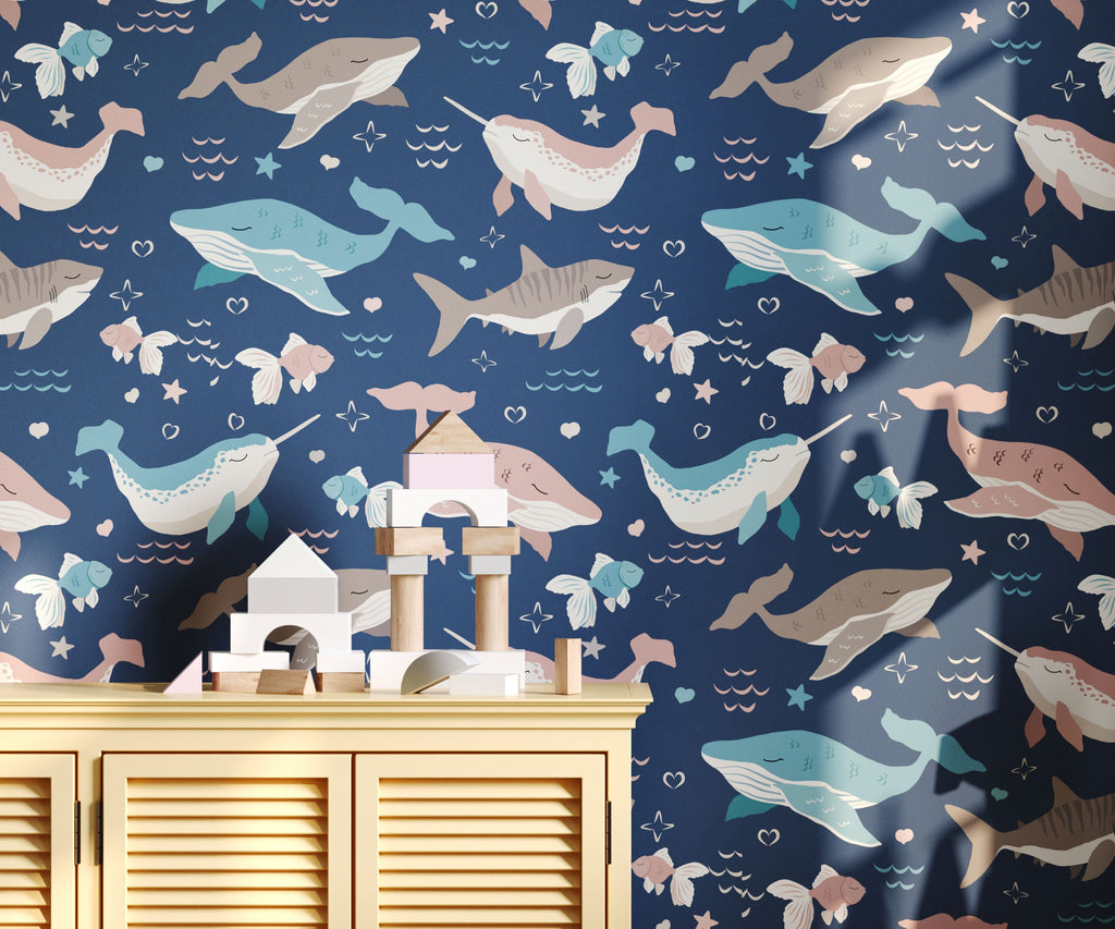 Wallpaper with whale pattern on a blue background, with a wooden cabinet and toys in the foreground.