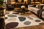 Multicolored area rug with circular patterns on a wooden floor in a living room setting.