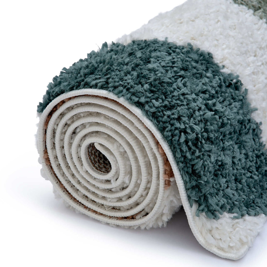 Roll of green and white textured rug on a white background