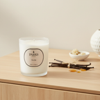 Parks London vanilla candle on a wooden surface with vanilla beans and pods.