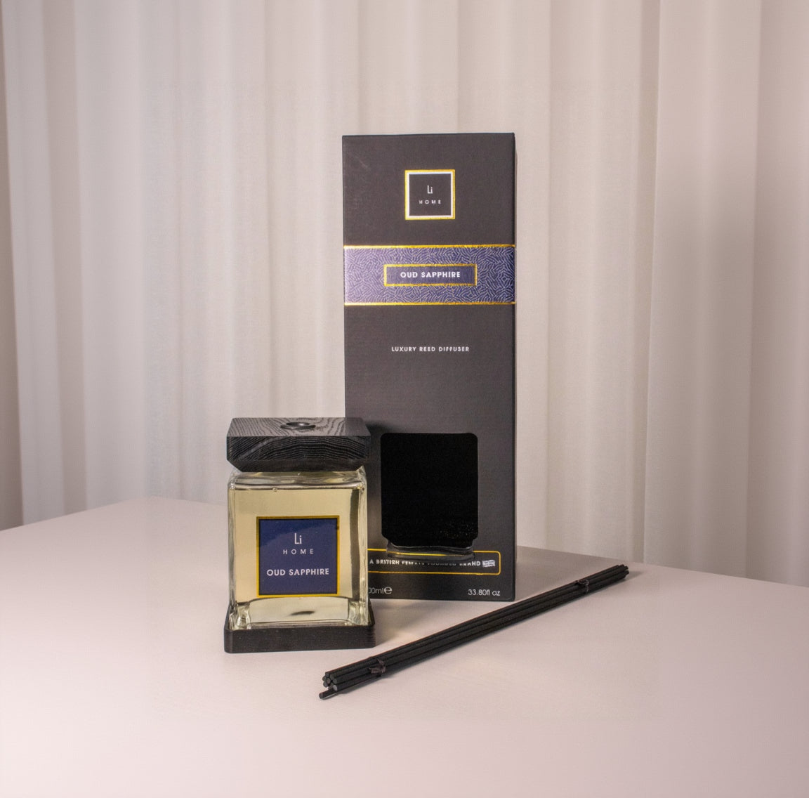 Oud Sapphire diffuser and packaging on a neutral background