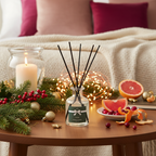 Decorative diffuser bottle on a table with festive items including candles, fruits, and lights.