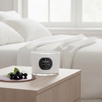 White candle with a label on a wooden table in a living room setting