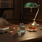A desk setup with a diffuser, glass of liquid, and lamp in a cozy room.