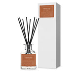 Firewood diffuser bottle with black sticks and packaging on a white background