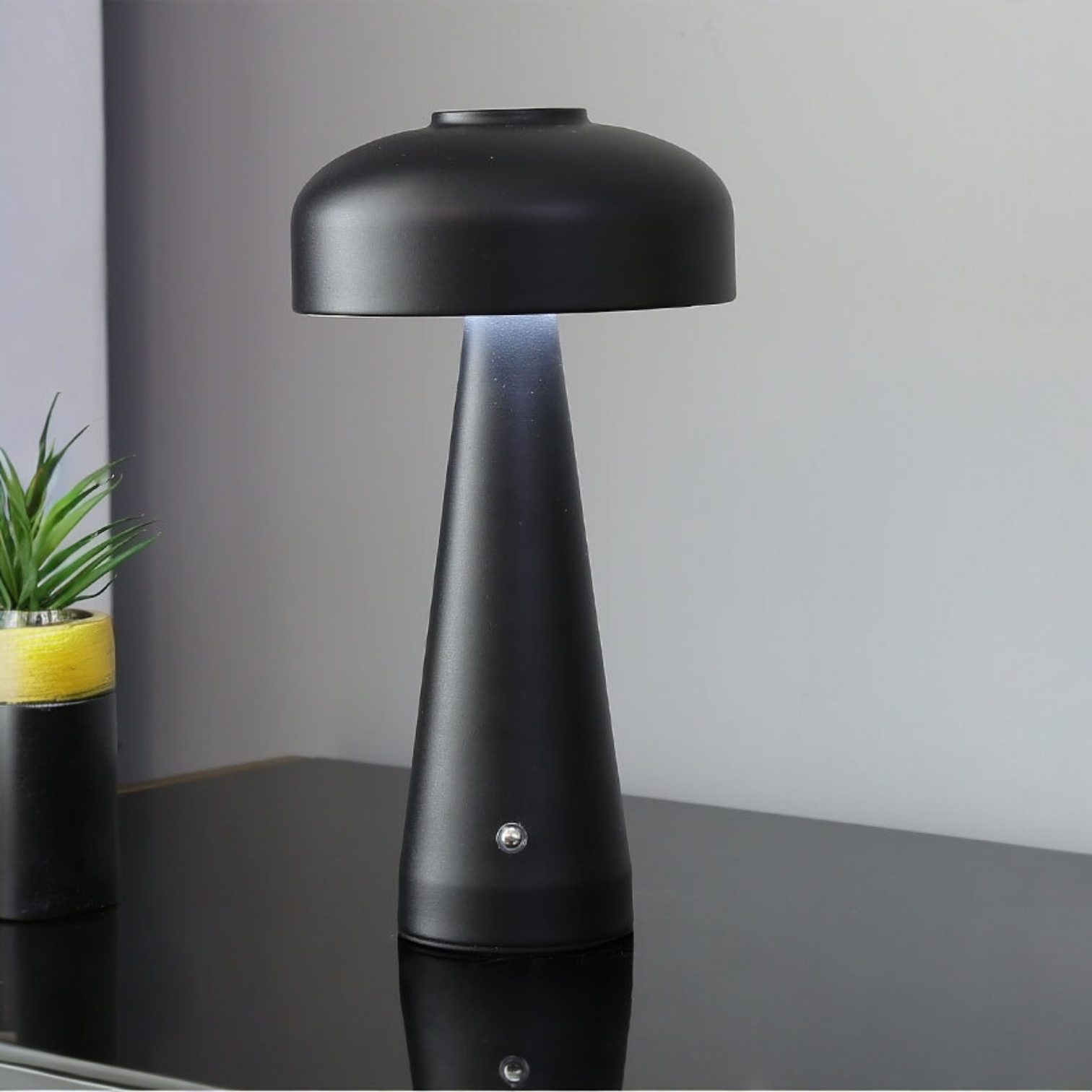 Black table lamp on a reflective surface with a blurred background