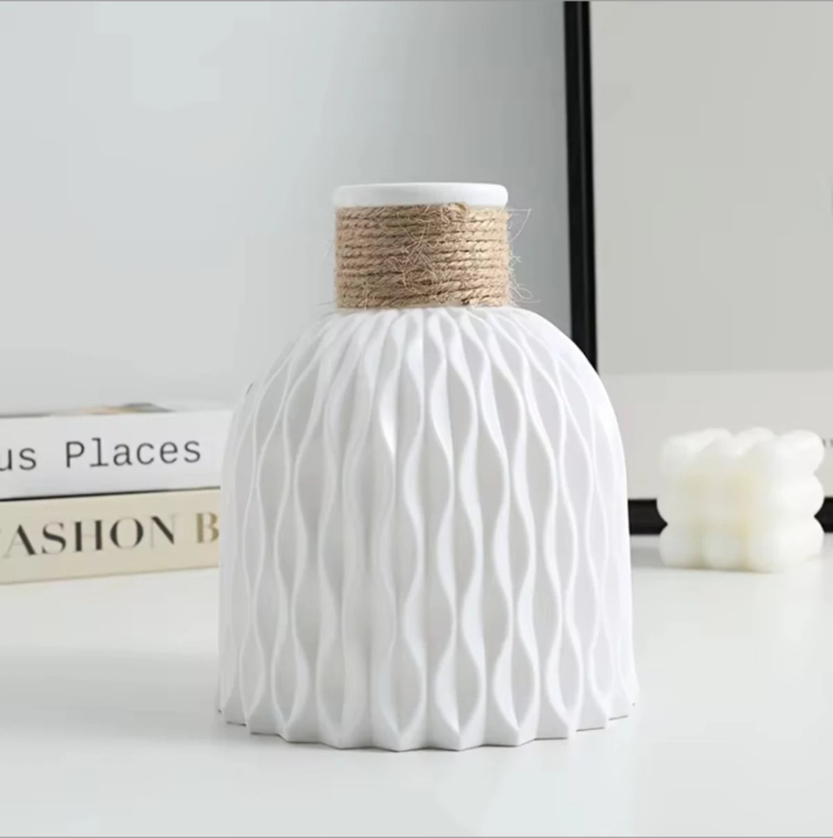 White textured vase with woven top on a light surface