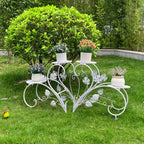 Decorative white metal plant stand with potted plants on a grassy area
