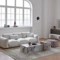 Modern living room with a white sofa, marble coffee table, and decorative items.