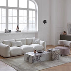 Modern living room with a white sofa, marble coffee table, and decorative items.