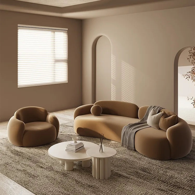 Modern living room with brown sofa and chairs, white coffee table, and neutral walls.