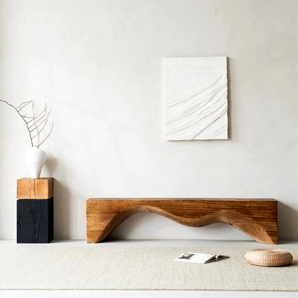 Wooden bench in a minimalistic room with abstract art on the wall.