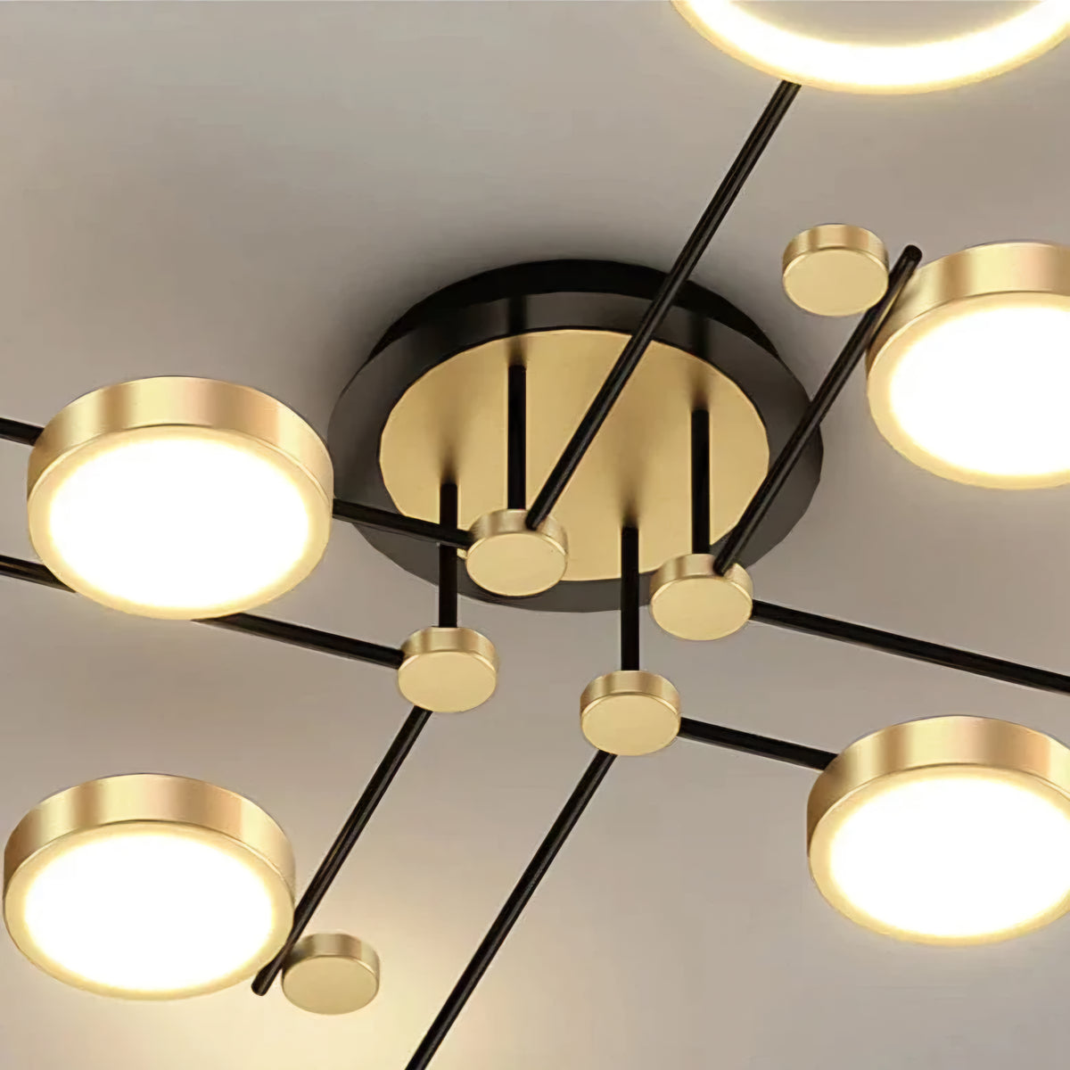 Modern ceiling light fixture with gold and black design on a neutral background
