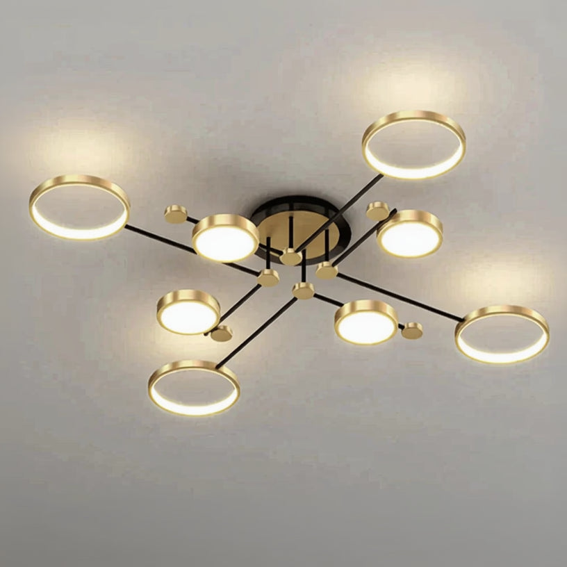 Modern ceiling light fixture with gold rings on a plain background