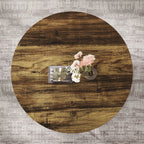 Round wooden table with decorative items on a textured gray surface