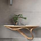 Wooden console table with a bonsai tree against a gray wall