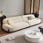 Beige sofa in a living room with a round coffee table and decorative items.