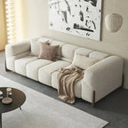 Beige sectional sofa in a living room with abstract art on the wall.