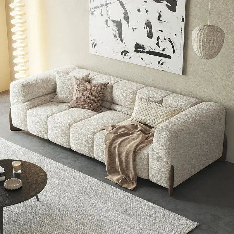 Beige sectional sofa in a living room with abstract art on the wall.