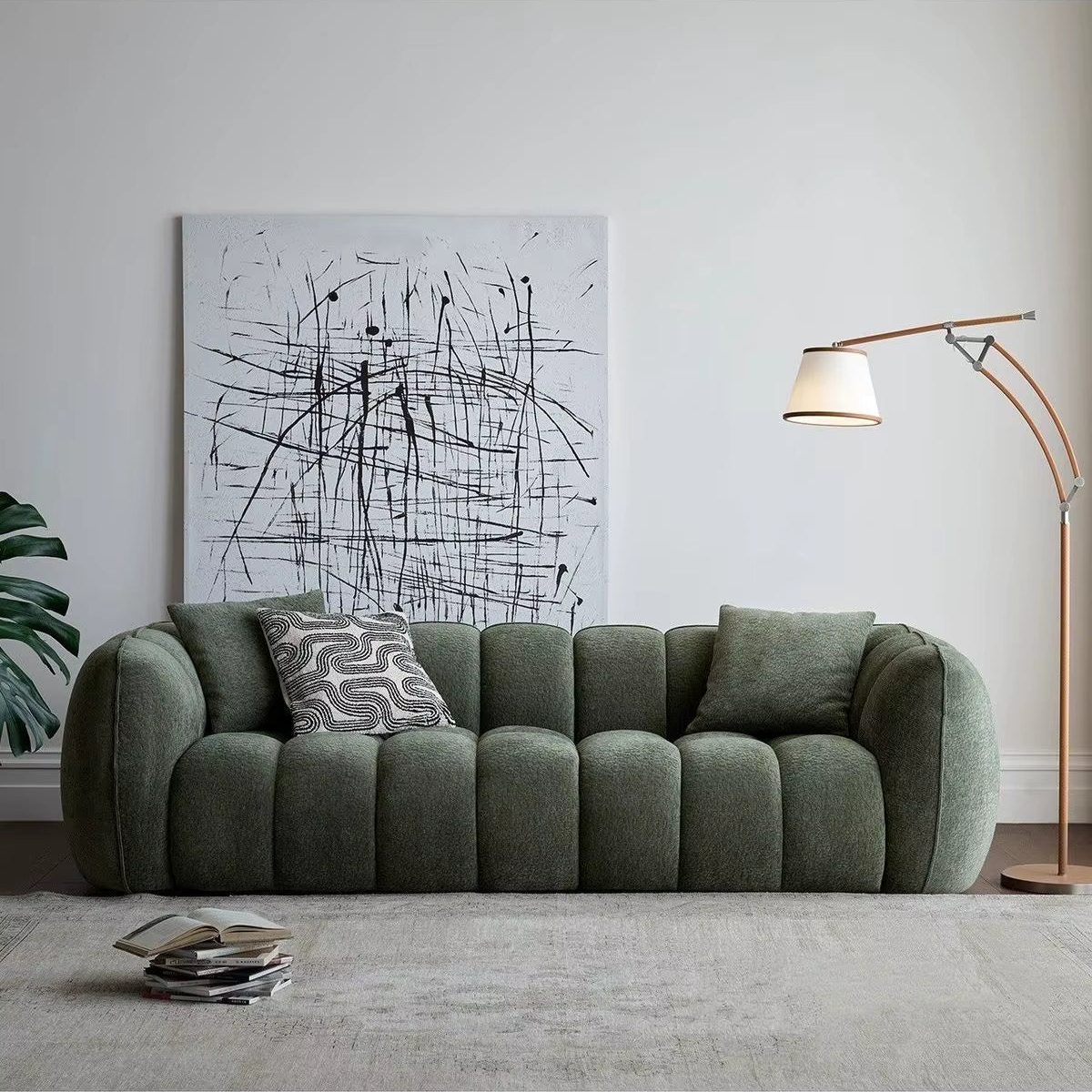 Green sofa in a living room with abstract art and a lamp.