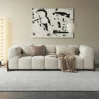Modern living room with a beige sofa, abstract painting, and pendant light.