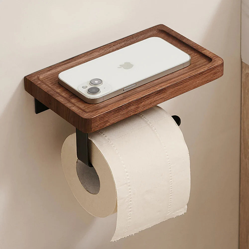 Wooden shelf with a smartphone and toilet paper holder on a beige wall.