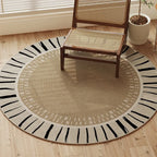 Round rug with black and white pattern on a wooden floor, chair placed on it.