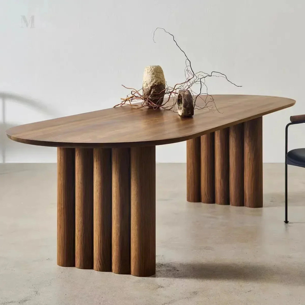 Wooden dining table with a minimalist design on a light floor.