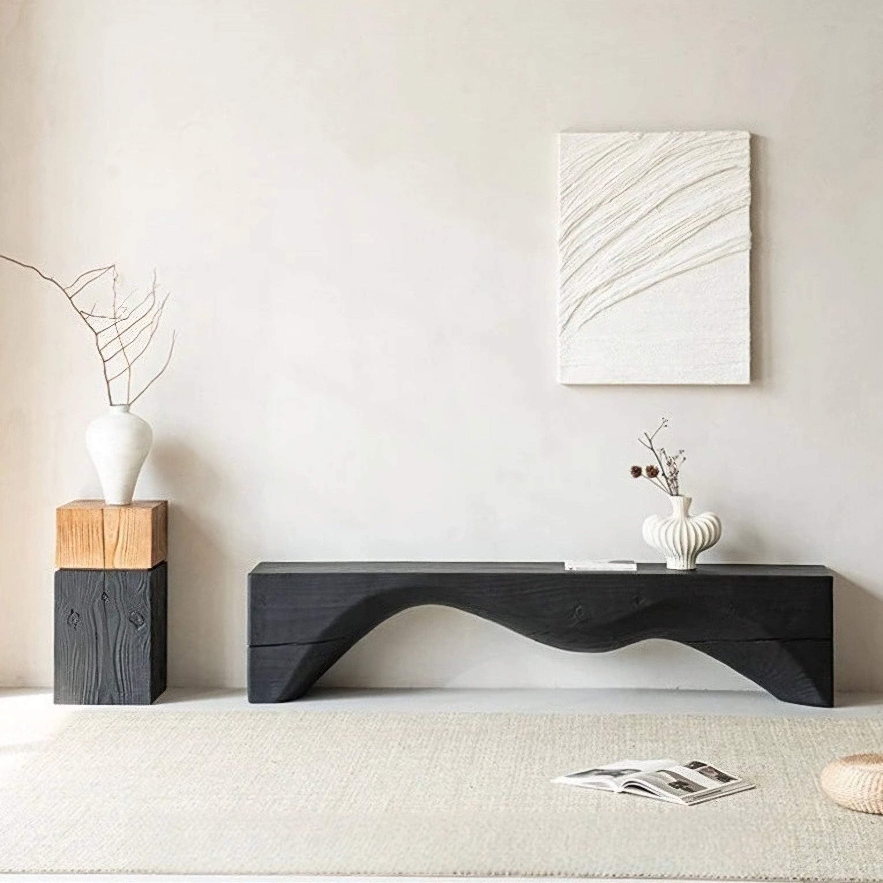 Modern living room with a black console table, decorative vases, and abstract wall art.