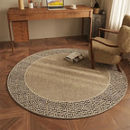 Round beige rug on a wooden floor with a desk and chair in the background