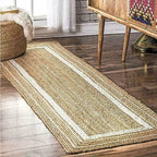 Woven jute rug on a wooden floor with a wooden side table and decorative items in the background.