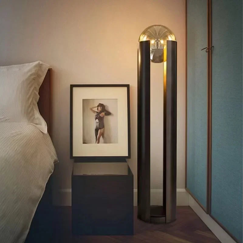 Modern bedroom with a bed, framed picture, and tall floor lamp.