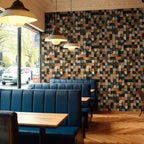 Restaurant interior with blue booths and a patterned wall.