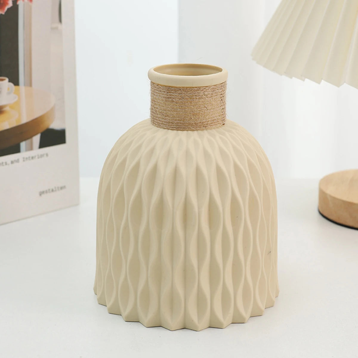 Beige textured vase with woven top on a white surface