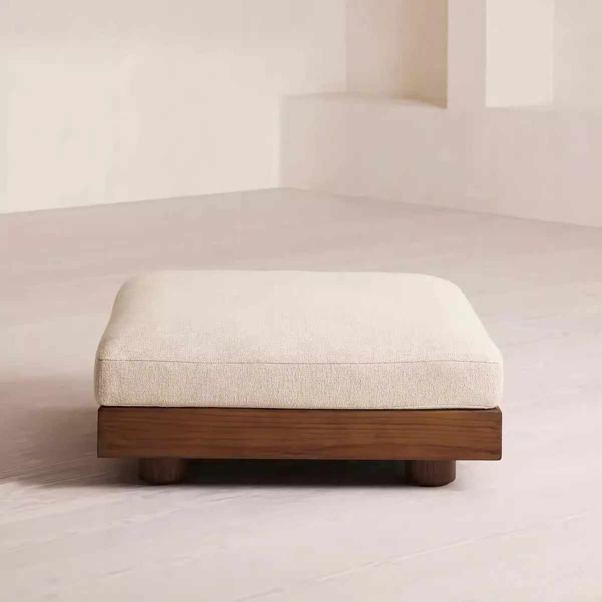 Stool with wooden base and white cushion on a neutral background