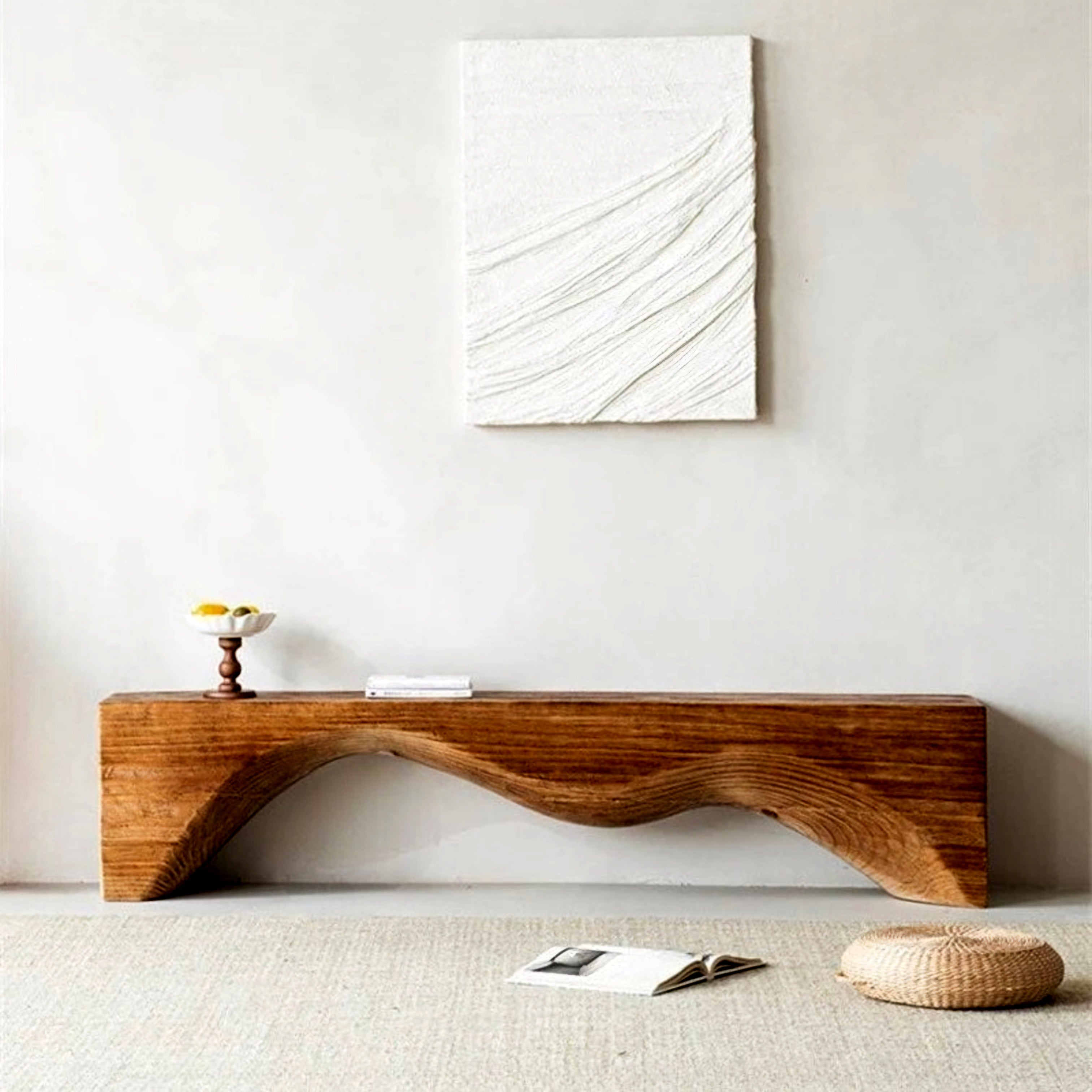Wooden console table against a white wall with abstract art above it