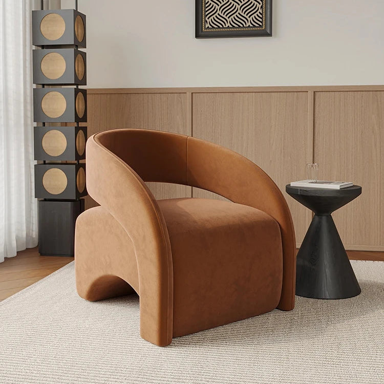 Modern brown armchair in a room with a geometric wall art piece and a side table.
