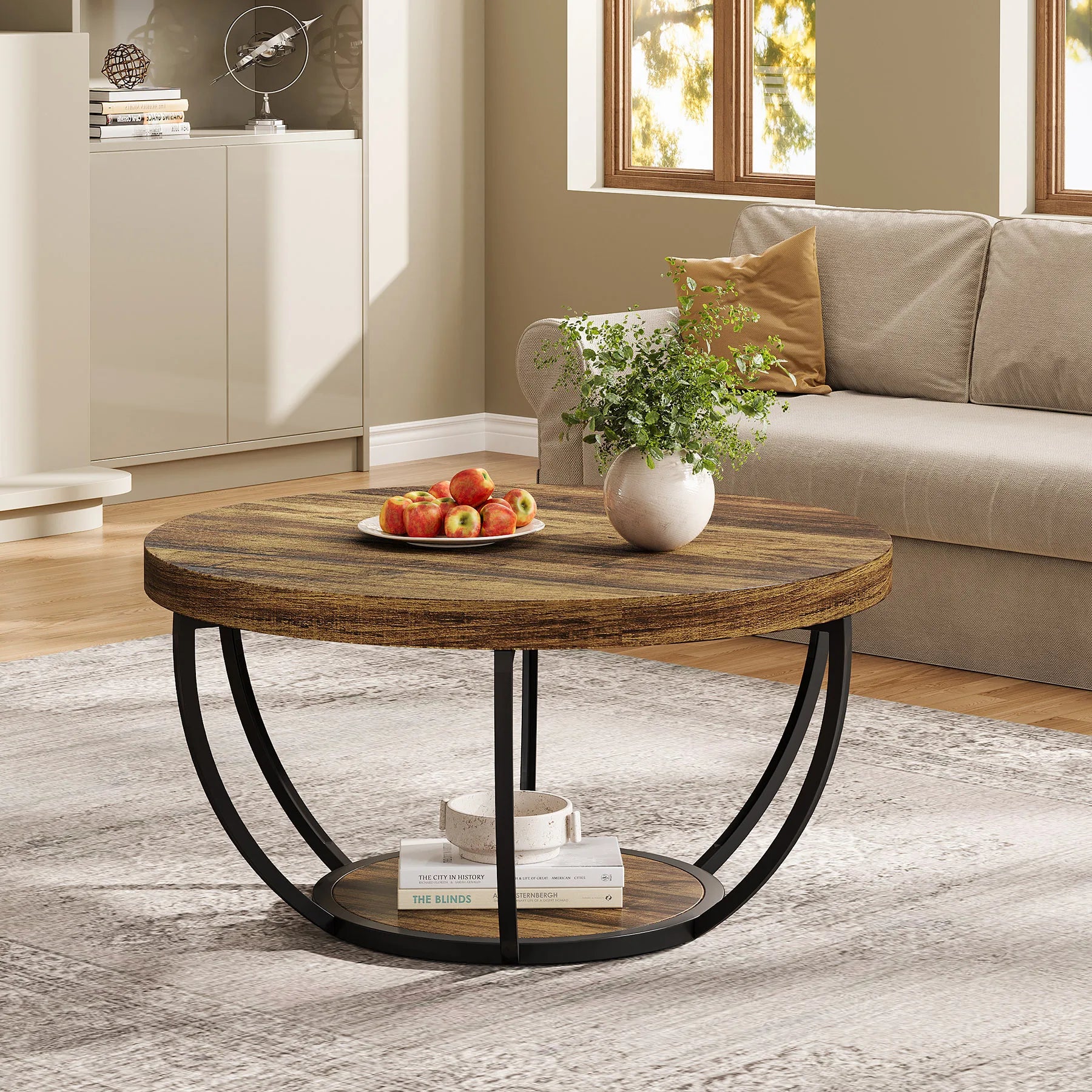 Round wooden coffee table with metal legs in a living room setting.