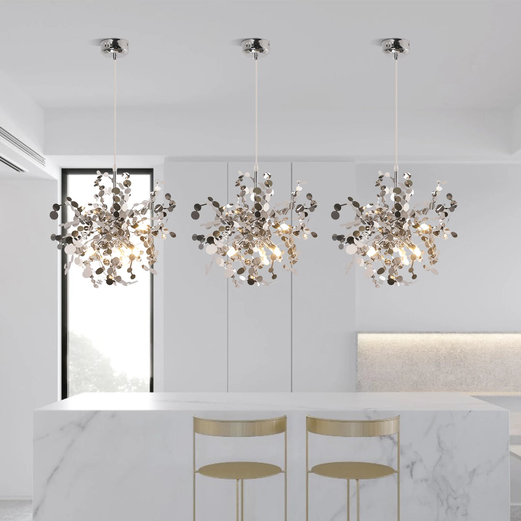 Modern chandelier hanging in a stylish interior setting with marble countertop and stools.