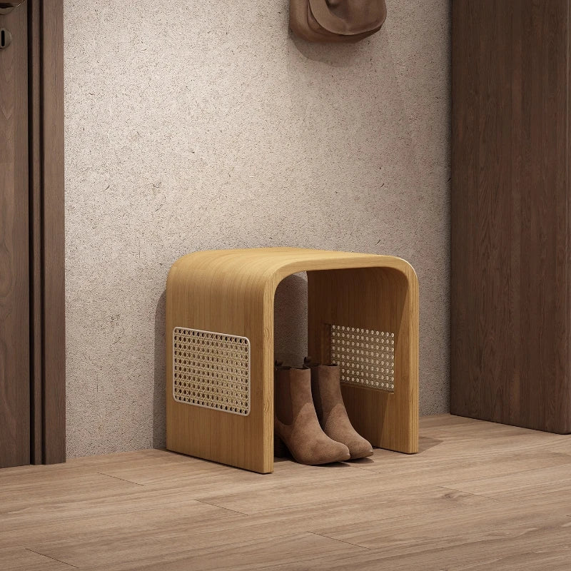 Wooden shoe storage bench with boots underneath in a hallway setting.