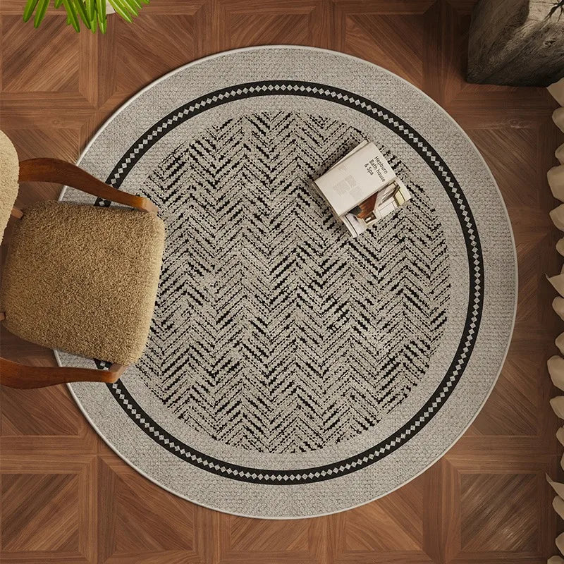 Round patterned rug on a wooden floor with a chair and plant.