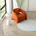 Orange armchair in a modern living room with a white side table and patterned rug.