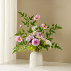 Bouquet of flowers in a white vase on a shelf with a beige wall background