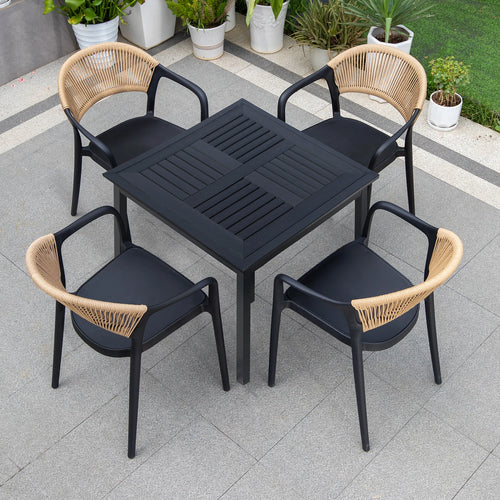 Black outdoor table with four matching chairs on a patio